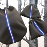 L'ensemble « sport chic » se compose de trois sacs à cordon noirs à rayures verticales bleues et blanches rappelant le style équestre, sur un fond noir et blanc à motifs d'arbres. Ils sont les accessoires parfaits pour une balade chic à Lyon.