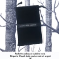 Une pochette cadeau en daim noir avec une étiquette "Wouah dada couture" est mise en valeur sur un fond à motifs d'arbres. Elle est parfaite pour les passionnés d'équitation pour transporter des accessoires stylés comme le bracelet cuir manchette. Prix : 3€.